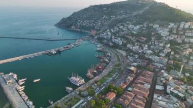 Alanya 'nın rıhtım ve Akdeniz kıyısındaki canlı şehir merkezinin çarpıcı hava manzarasını izleyin..