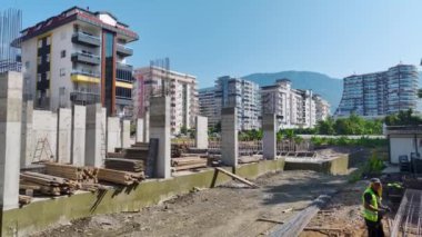 İnşaat ekibinin yeni bir binanın temelini atarken beton dökmesine bakın..