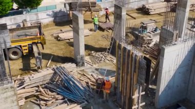 Yeni bir yapının temelini oluştururken beton döken işçileri izle.