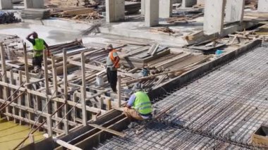 İnşaat işçileri büyük bir yapının temelini atarken beton döküyorlar..