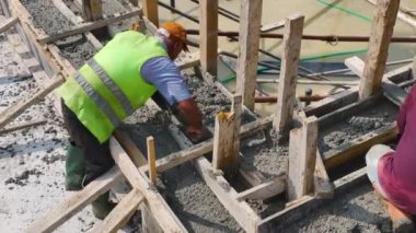 Yeni bir yapı inşa ederken beton döken işçilere bakın..