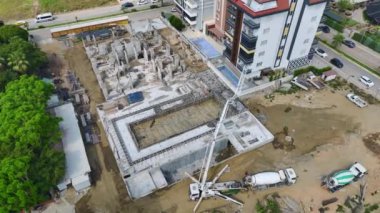 İnşaat alanında işçiler tarafından betonla döşenen bir binanın temelini görün..