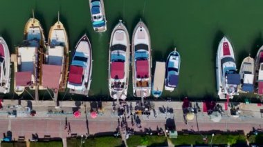 Canlı bir yat festivali izleyin. Yüksek sesli müzik çalan bir DJ ve denizde dans eden insanlar..