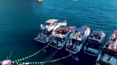 Açık denizdeki bir DJ 'in dans edip yüksek sesle müzik dinlediği bir yat festivali izleyin..