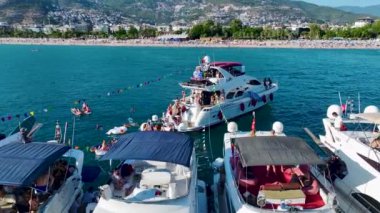 Yat festivalinde yüksek sesli müzik çalan bir DJ ve açık denizde parti yapan insanların eğlencesini izleyin..