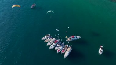 İnsanların parti yaptığı bir yat festivali, müzik çalan bir DJ ve açık denizde eğlenceli bir atmosfer..