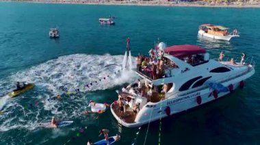 Canlı yat festivaline bakın. Bir DJ müzik çalıyor ve insanlar açık denizde dans ediyor..