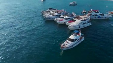 Eğlenceli yat festivalini bir DJ 'le, yüksek sesli müzik eşliğinde ve insanlar açık denizde yatlarda parti yaparken izleriz..