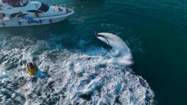 Açık denizde bir yat partisinin heyecanını görün. Bir DJ ve yüksek sesli müzik havayı dolduruyor..