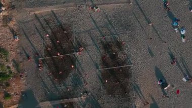 Oyuncuların kumlu sahilde koşup topa vurduğu canlı bir plaj voleybolu maçı seyredin..