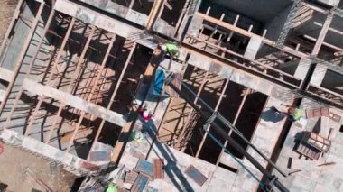 Yeni bir inşaat projesinin temelleri için inşaat demirini güvence altına alan işçiler.