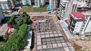 İnşaat işçilerinin beton bir yapının temelini oluşturmak için demirle uğraşmasını izle.