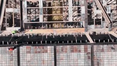 İşçiler inşaat alanındaki demirleri dikkatlice bağlayarak binanın temelini güçlendiriyor..