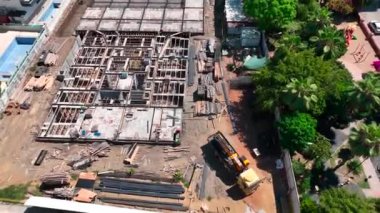 İşçiler yoğun bir inşaat sahasında temel çalışması için demirle uğraşırken, güçlü bir yapı sağlıyorlar..