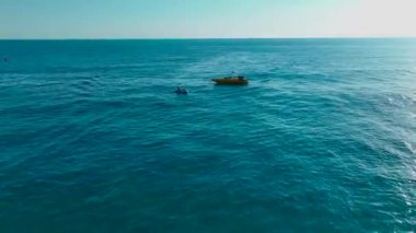 Jet ski sürücülerinin keskin virajlar aldıklarını ve suda hareketli bir şekilde zıpladıklarını görün..