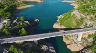 Yolculukta bir mankeni izle, güzel bir nehir boyunca üstü açık bir araba sür ve pitoresk bir köprüden geç..