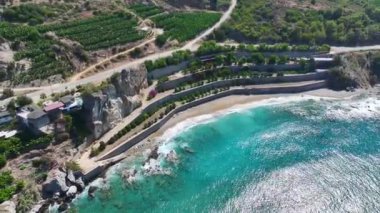 Huzurlu bir bahçe tarafından kucaklanmış, Akdeniz 'de huzurlu bir plajı seyredin..