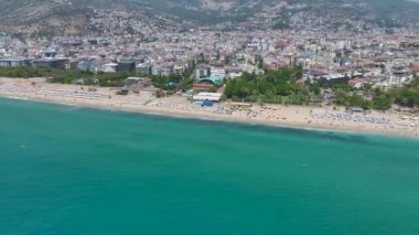 Partilerin ve toplantıların yapıldığı beyaz yatlarla dolu güzel, masmavi sahili seyret..