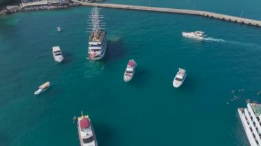 Güzel gök mavisi sahil şeridi boyunca beyaz yatlarda gerçekleşen canlı partilerin ve etkinliklerin tadını çıkarın..