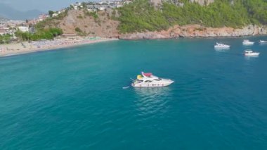 Canlı partilerin tadını çıkarın. Canlı gök mavisi kıyı şeridi boyunca demirli beyaz yatlarda..