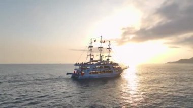 Gök mavisi sahil boyundaki beyaz yatlara bakın. Suda eğlence ve şenlik partileri düzenliyorlar..