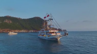 Canlı partilerin ve toplantıların yapıldığı, beyaz yatlarla dolu, masmavi kıyı şeridine dikkat edin..