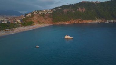 Denizde canlı partiler veren beyaz yatlarla dolu güzel gök mavisi kıyı şeridine bakın..