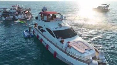 DJ 'i müzik çalarken ve kızlar gök mavisi kıyılarda beyaz yatlarda dans ederken izleyin..