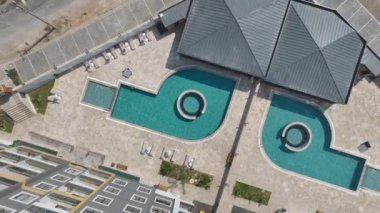 İnşaatın sonlarına doğru masmavi bir havuzu olan çarpıcı bir konut kompleksi görün..