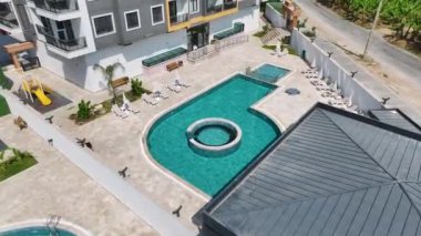 Işıl ışıl masmavi bir havuzu olan neredeyse bitmiş bir konut kompleksini izleyin..