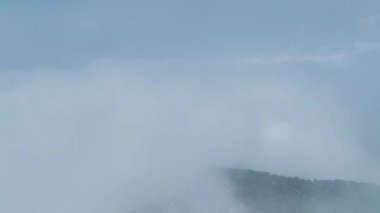 Yeşil ormanları ve geniş açık alanları olan bulutlu dağların sihirli manzarasını izleyin..