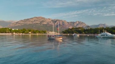 Şafak vakti Antalya Kemer kıyıları boyunca temiz ve mavi sularda yüzen lüks yatlar görün..