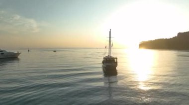 Antalya Kemer 'in üzerindeki güneşin doğuşuna bakın. Yatları kenetlenmiş ve altın plajları sabah ışığında parlıyor..