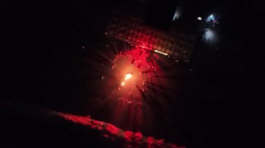 Büyük bir grup sıcak bir şenlik ateşinin etrafında dans ediyor ve rahatlıyor, festival atmosferinin tadını çıkarıyor..