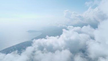 Huzurlu bir orman bulutlu bir dağ manzarasının altında, sakin ve huzurlu bir manzara yaratıyor..