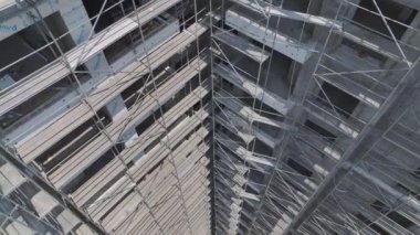 İşçiler inşaat sahasında çok çalışıyorlar, adanmışlıkla yüksek katlı bir konut inşa ediyorlar..