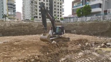 4K 'da bir inşaat sahasındaki bir temele toprak boşaltma sürecine bakın..