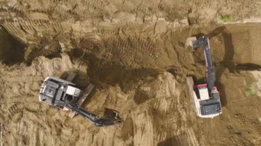 Çalışan bir kazıcı ve kamyon için havadan 4K görünümü olan vakıfların inşasını deneyin