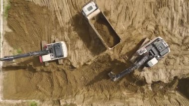 Toprağı kazarken ve taşırken bir kazıcı ve kamyonlar görmüşler. Detaylı olarak 4K içinde çekilmişler.