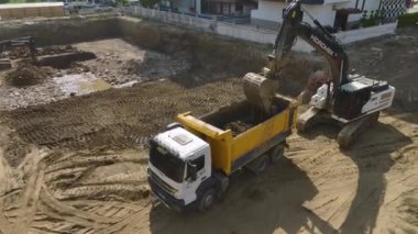 4K 'da ele geçirilen toprak kazıcı ve kamyonlarla emlak inşaatının başlangıcını tecrübe edin..