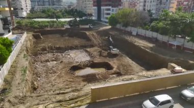 Yoğun bir inşaat sahasında kamyonlara toprak yükleyen kazıcıyı izleyin, yukarıdan çarpıcı bir şekilde 4K 'da yakalandı..