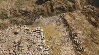 Yüksek çözünürlüklü 4K ile yakalanan toprağı kamyonlara yükleyen bir kazıcı ile site hazırlama çalışmasına bakın.