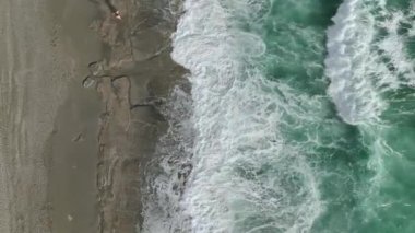 Akdeniz kıyısındaki fırtınalı gök mavisi denizin gücüne tanık olun, yukarıdan çarpıcı bir şekilde 4K 'da yakalandı..