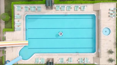 Lüks bir evdeki büyük bir gök mavisi havuzun 4K hava görüntüsünü izleyin. Güzel ve ferahlatıcı bir sahne..