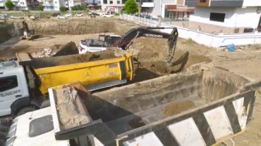 İnşaat alanındaki ağır ekipmanların 4K insansız hava aracı görüntüsünü izleyin. Güçlü ve çalışkan..