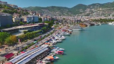 Alanyas Körfezi 'nin yatları, tekneleri, gök mavisi suyu ve tarihi mimarisi olan 4K insansız hava aracı görüntülerine bakın..