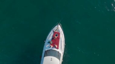 Alanya 'da yatları ve tarihi binaları olan bir marinanın 4K hava görüntüsünü yakalayın. Güzel gök mavisi su.