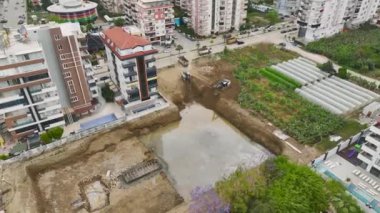 Projenin başında bir inşaat sahasında çalışan makinelerin 4K drone görünümüne bakın.