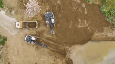 İnşaatçıların toprak ve vakıf işlerini yürüttüğü 4K hava görüntülerini izleyin. Ağır makineler çalışıyor.