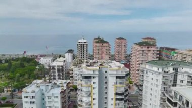 Akdeniz kıyısındaki lüks bir gökdelenin 4K hava görüntüsü. Modern tasarım ve güzel deniz manzarası.